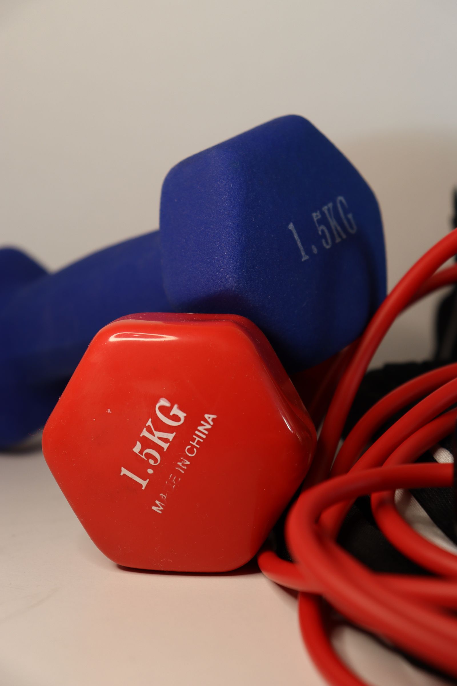A close-up shows dumbbells and resistance bands together as two different home-training tools.