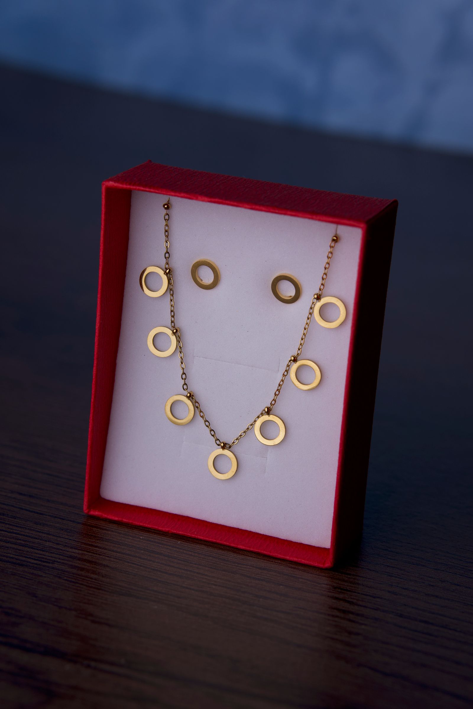A gold-tone necklace and earrings sit in a gift box; the pictured jewelry is illustrative and is not Atolea’s Calvi chain.