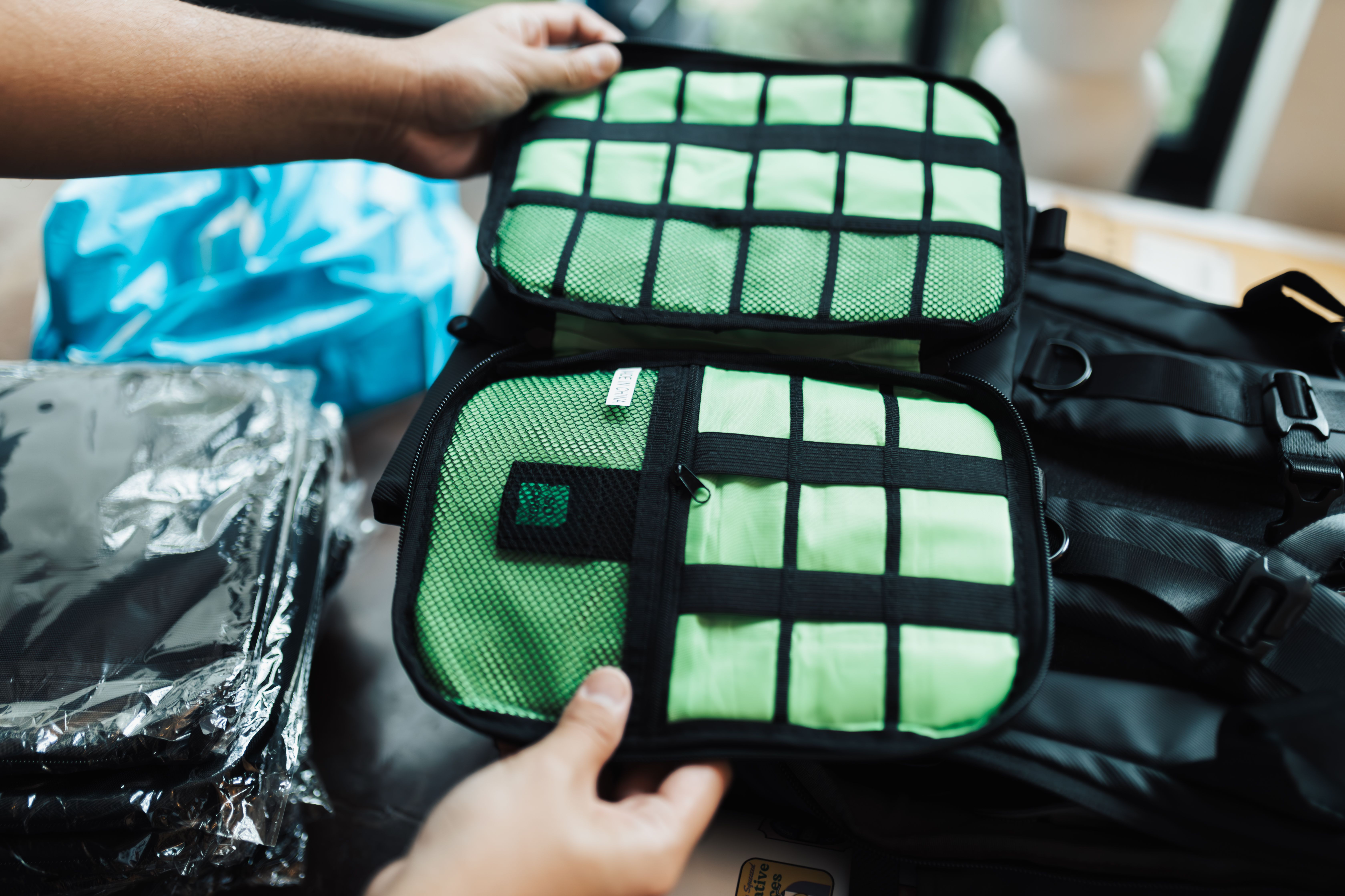 Hands arrange a green packing cube inside travel luggage. The cube is illustrative and is not a named product recommendation.