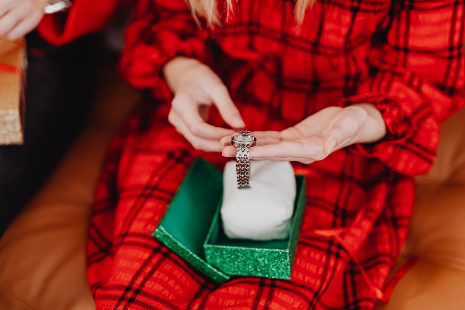 A person holds a silver wristwatch above a green gift box; this is an illustrative gift scene, not a Boderry product photo.