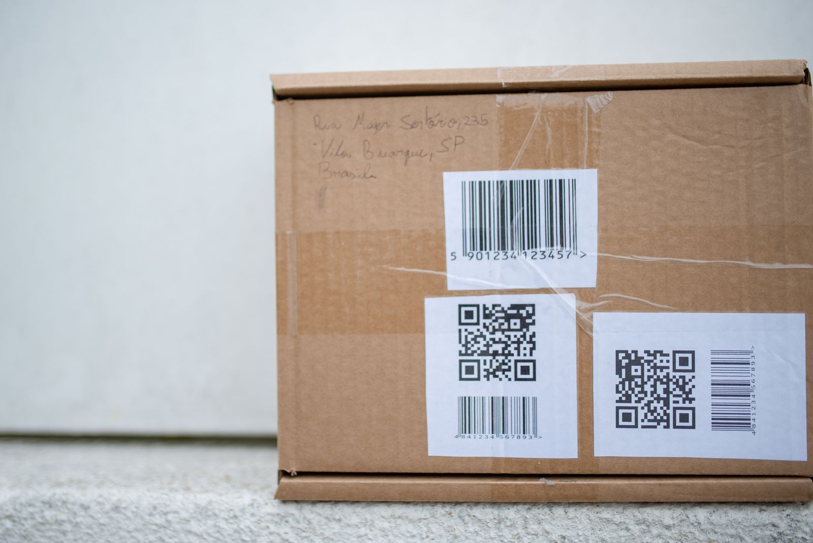 A close-up package carries a shipping barcode; it illustrates why label size and scan readability matter.
